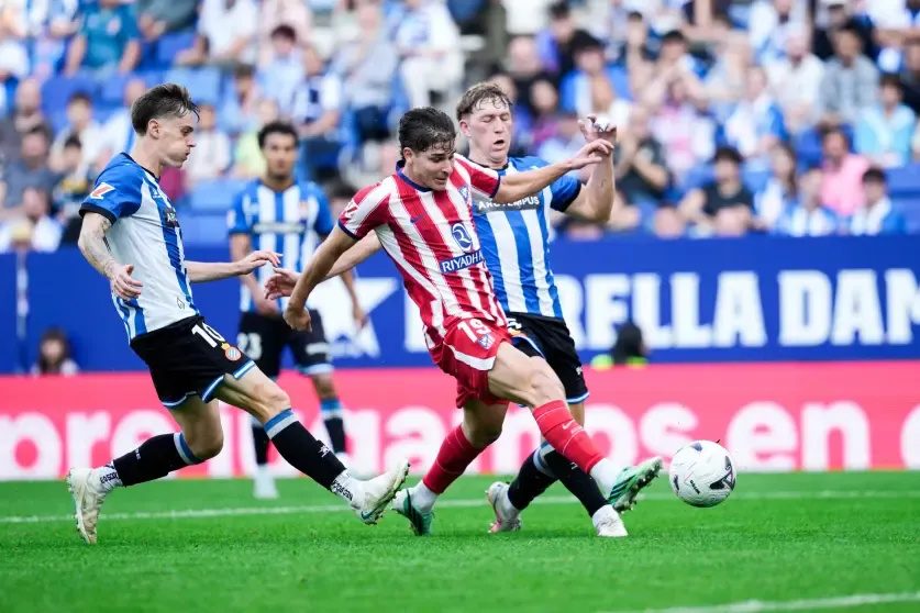 Julián Álvarez disputa un balón ante dos futbolistas del Espanyol